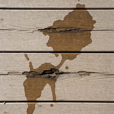 Close-up of a damaged balcony surface with visible cracks and water stains